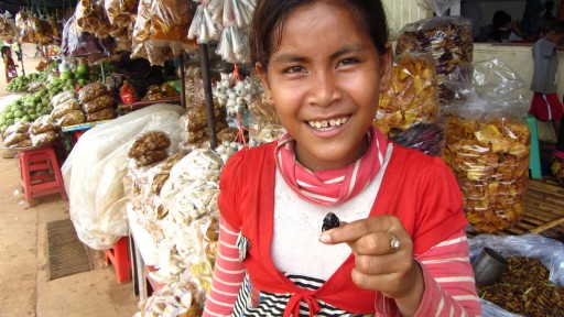 A Cambodian girl demonstrating her cockroach-eating skills